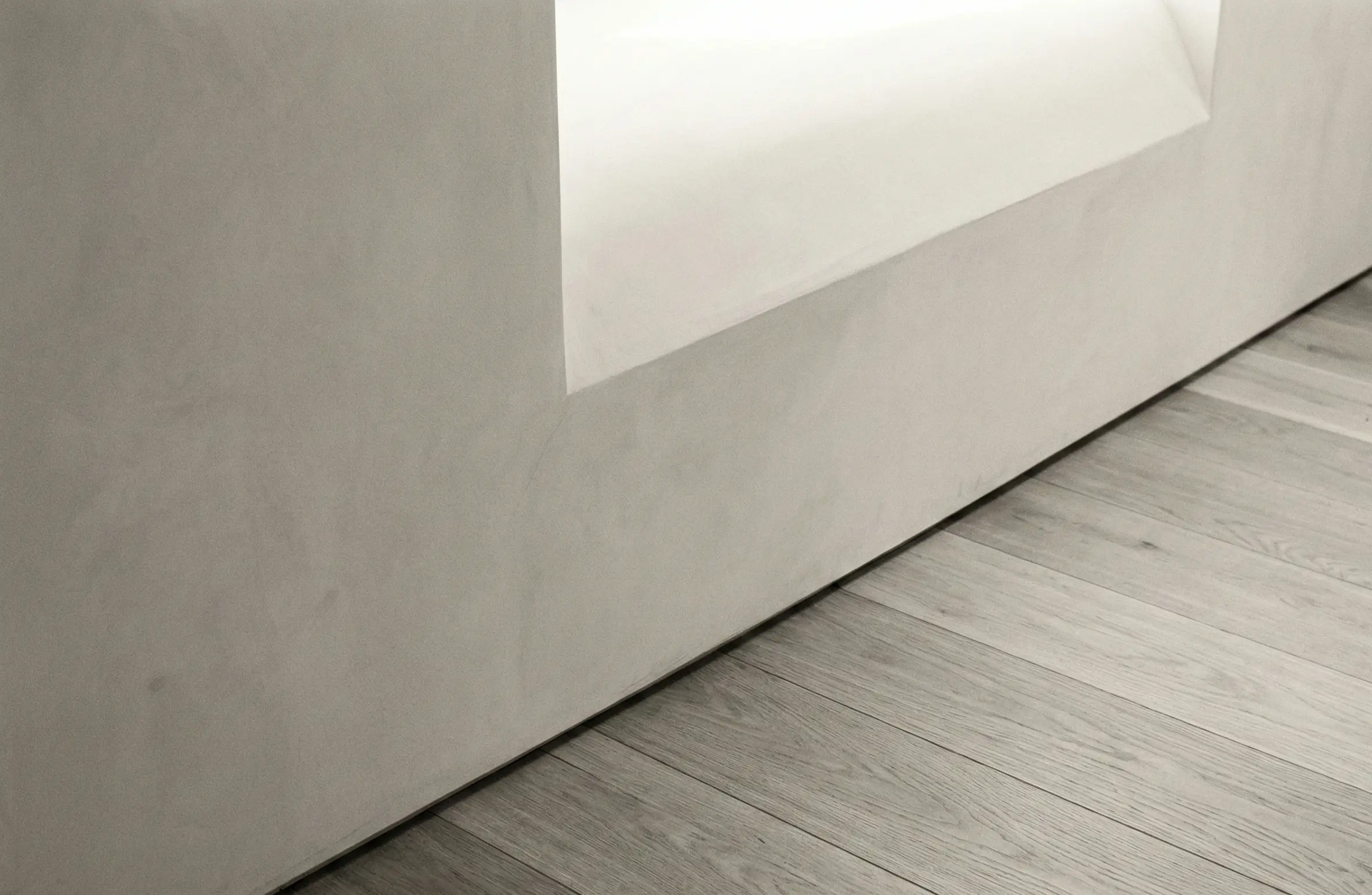 Plaster wall meeting wooden floor